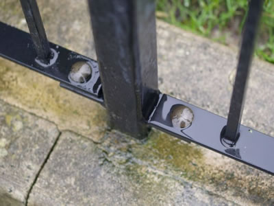 Black powder coated palisade fence with the square type post fixed in the concrete.