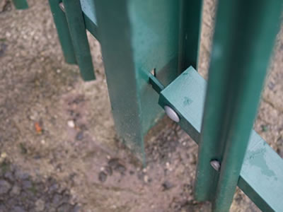 The green powder coated RSJ beam palisade post is fixed in the ground.