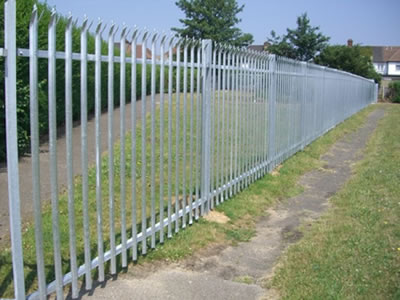 A long row of galvanized palisade fence serves as the security fence to separate the greenbelt and the outside.